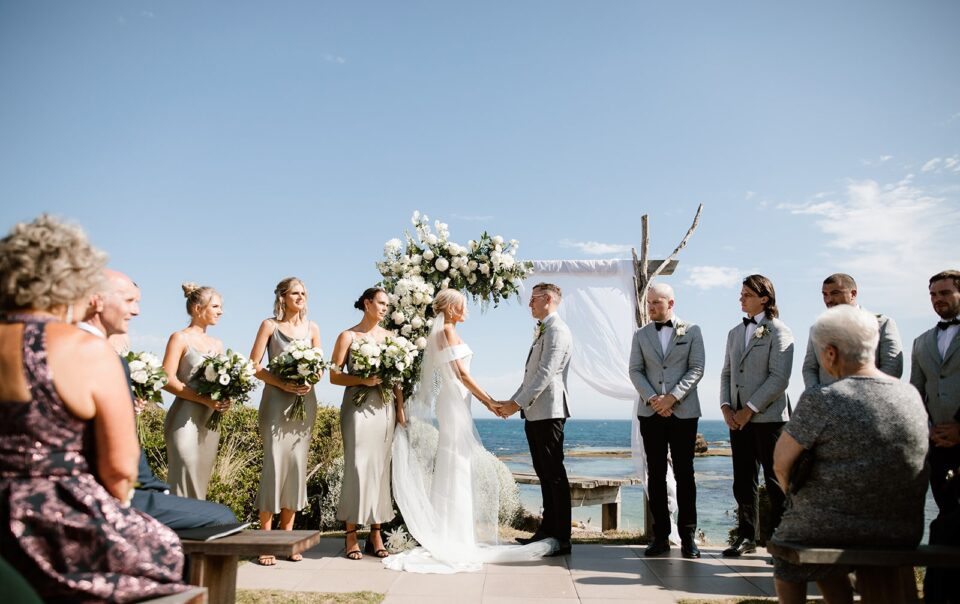 an all smiles sorrento wedding day, with the couple standing under the ocean backdrop arbour